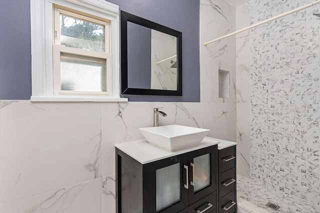 bathroom with vanity, tile walls, and a tile shower