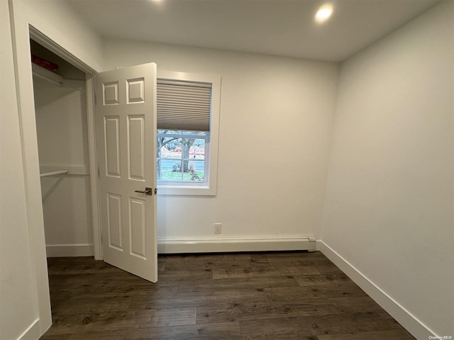 interior space with baseboard heating and dark wood-type flooring