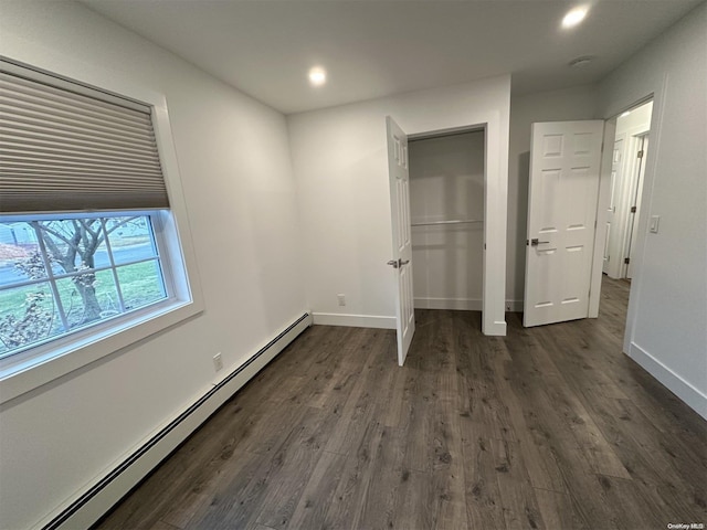 unfurnished bedroom featuring a baseboard radiator and dark hardwood / wood-style floors