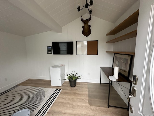 interior space with wood-type flooring and vaulted ceiling with beams