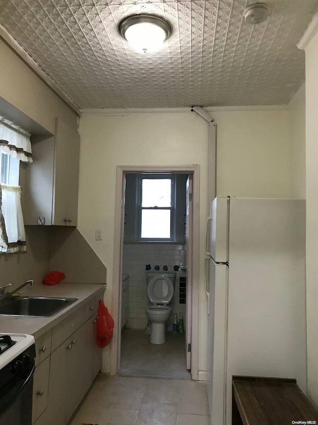 bathroom featuring tile patterned flooring, vanity, toilet, and tile walls