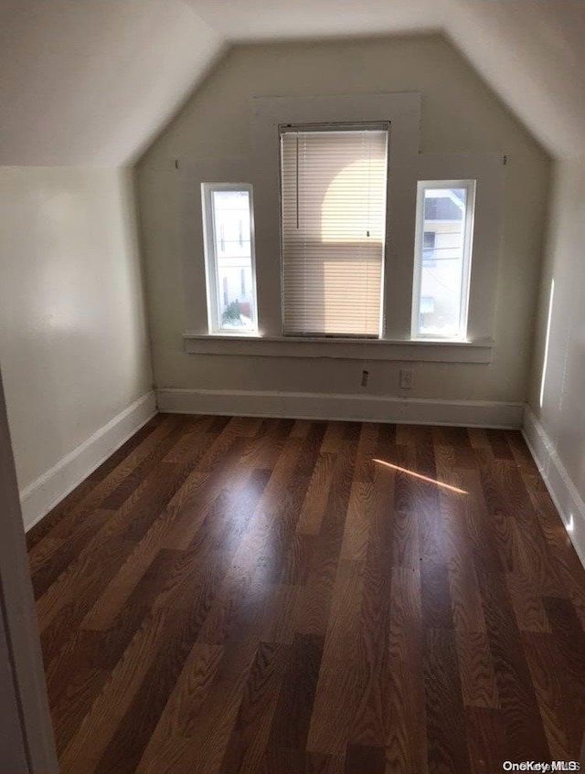 bonus room with lofted ceiling and dark hardwood / wood-style floors