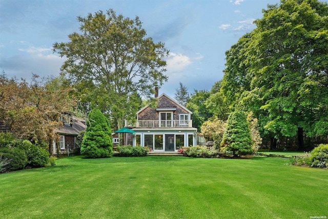 rear view of house with a sunroom and a lawn