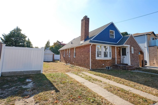 view of front facade with an outbuilding, a garage, and a front lawn