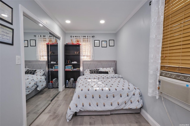 bedroom featuring wood-type flooring, ornamental molding, and a closet