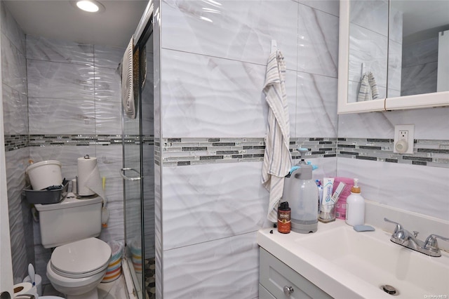 bathroom featuring vanity, toilet, and tile walls