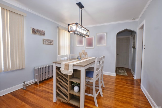 dining area with radiator, hardwood / wood-style floors, and ornamental molding