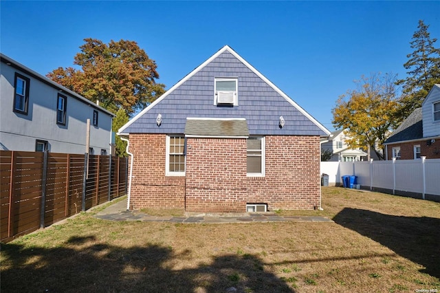 back of property with cooling unit and a lawn