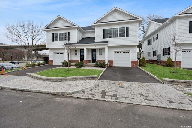 view of front of house with a porch, a garage, and a front lawn