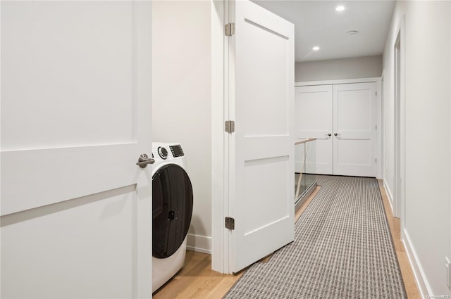 washroom with washer / dryer and light hardwood / wood-style flooring