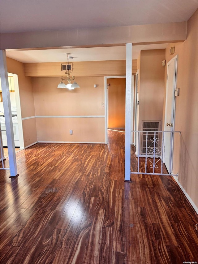 unfurnished room featuring heating unit, dark hardwood / wood-style flooring, and beamed ceiling