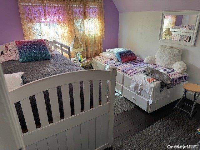 bedroom with dark hardwood / wood-style floors and lofted ceiling