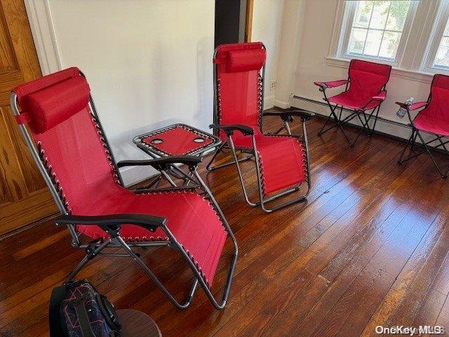 living area with dark hardwood / wood-style floors and a baseboard radiator