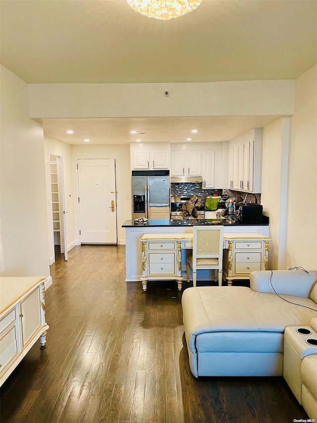 kitchen with hardwood / wood-style flooring, white cabinets, stainless steel fridge with ice dispenser, and tasteful backsplash