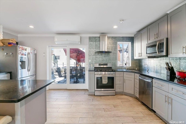 kitchen with stainless steel appliances, a wall unit AC, sink, wall chimney range hood, and gray cabinets