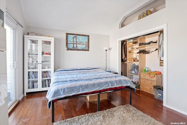 bedroom with a closet, dark hardwood / wood-style floors, and lofted ceiling