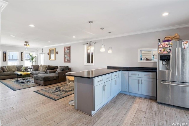 kitchen featuring stainless steel fridge with ice dispenser, kitchen peninsula, crown molding, pendant lighting, and light wood-type flooring