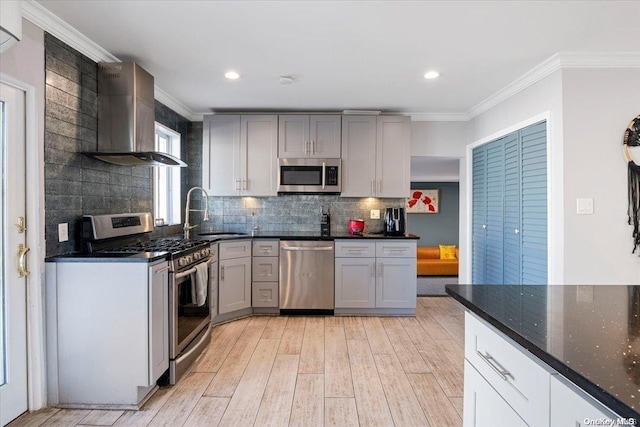 kitchen featuring dark stone counters, sink, gray cabinets, ornamental molding, and appliances with stainless steel finishes