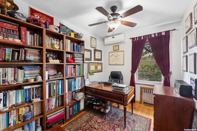 office space with hardwood / wood-style floors, ceiling fan, radiator heating unit, and a wall unit AC