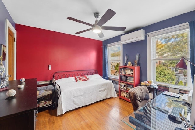 bedroom featuring a wall unit AC, ceiling fan, and hardwood / wood-style floors