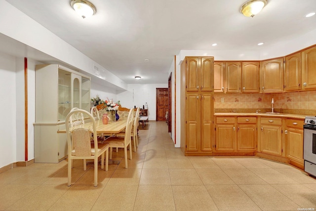 kitchen featuring decorative backsplash, stainless steel electric range, and sink