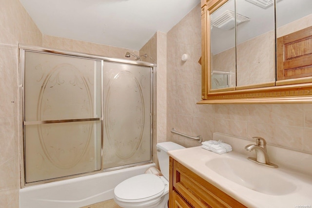 full bathroom with vanity, backsplash, combined bath / shower with glass door, toilet, and tile walls