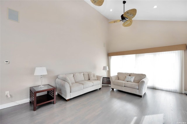 living room with a wealth of natural light, high vaulted ceiling, dark hardwood / wood-style floors, and ceiling fan