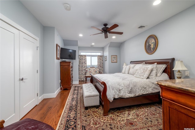 bedroom featuring a closet, light hardwood / wood-style floors, and ceiling fan