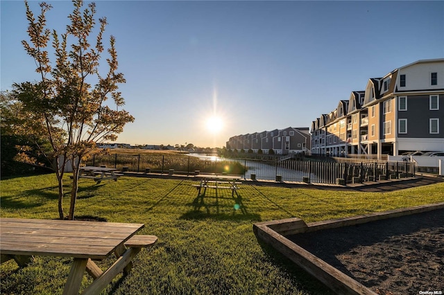 surrounding community featuring a water view and a lawn