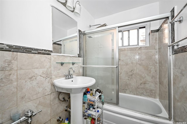 bathroom with tile walls and enclosed tub / shower combo