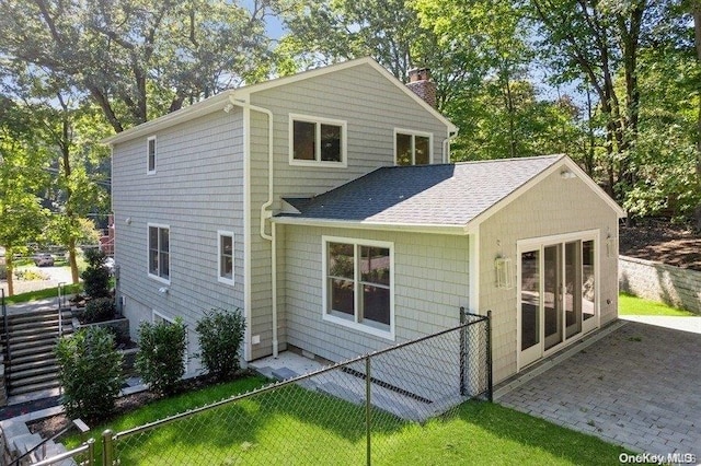 rear view of house with a lawn and a patio area