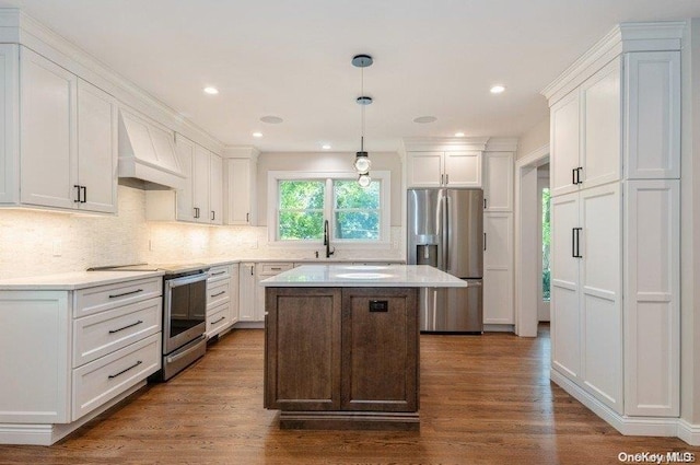 kitchen with premium range hood, dark hardwood / wood-style flooring, hanging light fixtures, and appliances with stainless steel finishes