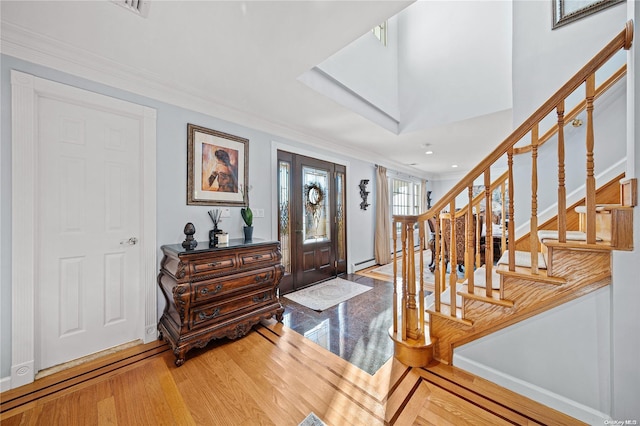 entryway featuring wood-type flooring and ornamental molding