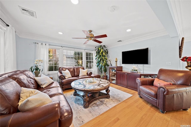 living room with light hardwood / wood-style floors, ceiling fan, and crown molding