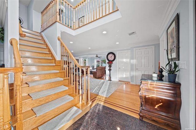 foyer with hardwood / wood-style floors, ceiling fan, and crown molding