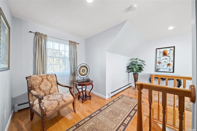 bedroom with hardwood / wood-style floors, vaulted ceiling, and a baseboard radiator