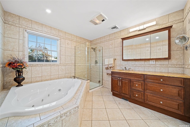 bathroom with tile patterned floors, vanity, shower with separate bathtub, and tile walls