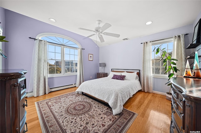 bedroom with ceiling fan, light hardwood / wood-style floors, lofted ceiling, and baseboard heating