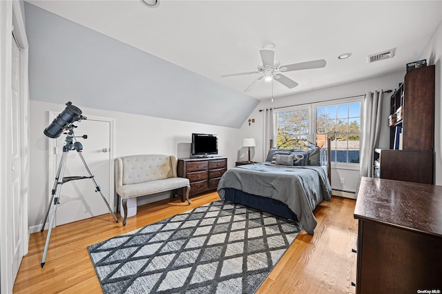 bedroom with light wood-type flooring, baseboard heating, ceiling fan, and lofted ceiling