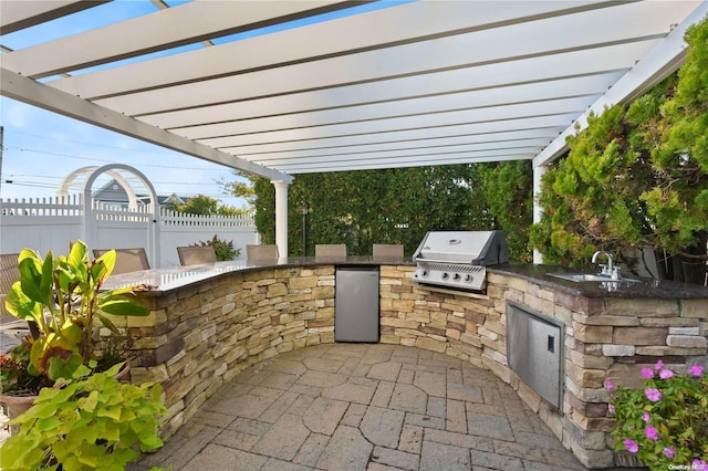 view of patio featuring a pergola, exterior kitchen, sink, and grilling area