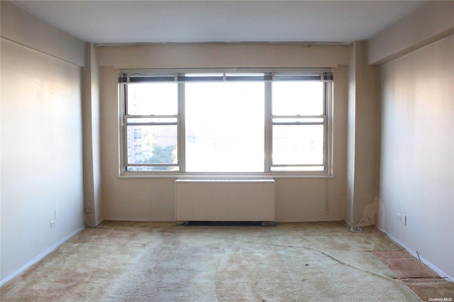 carpeted empty room with radiator