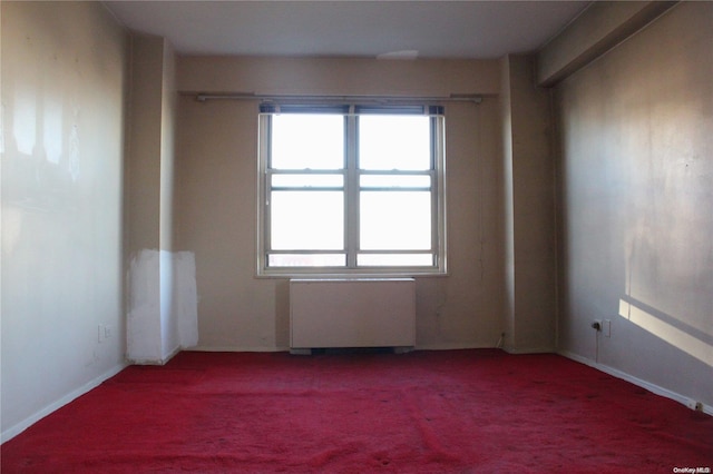 carpeted spare room with radiator heating unit