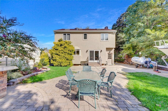 back of property with a yard and a patio area