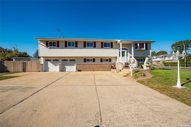 raised ranch with a front lawn and a garage