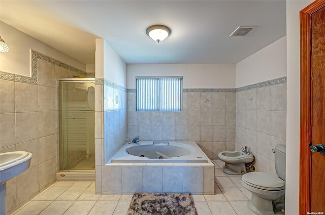 bathroom with toilet, shower with separate bathtub, tile patterned floors, and tile walls