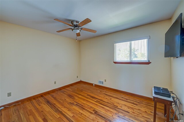 spare room with hardwood / wood-style flooring and ceiling fan