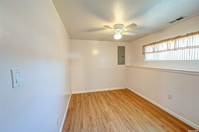 empty room featuring ceiling fan, electric panel, and light hardwood / wood-style flooring