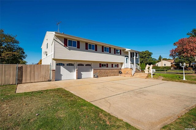 bi-level home with a garage and a front yard