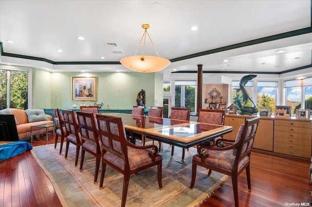 dining room featuring hardwood / wood-style flooring, a healthy amount of sunlight, and ornamental molding