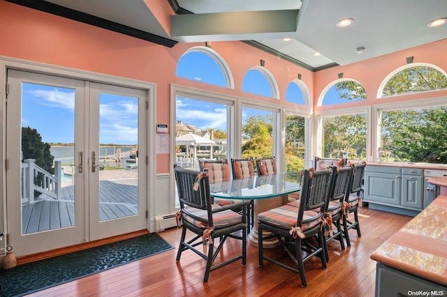 sunroom with french doors, a baseboard radiator, and lofted ceiling